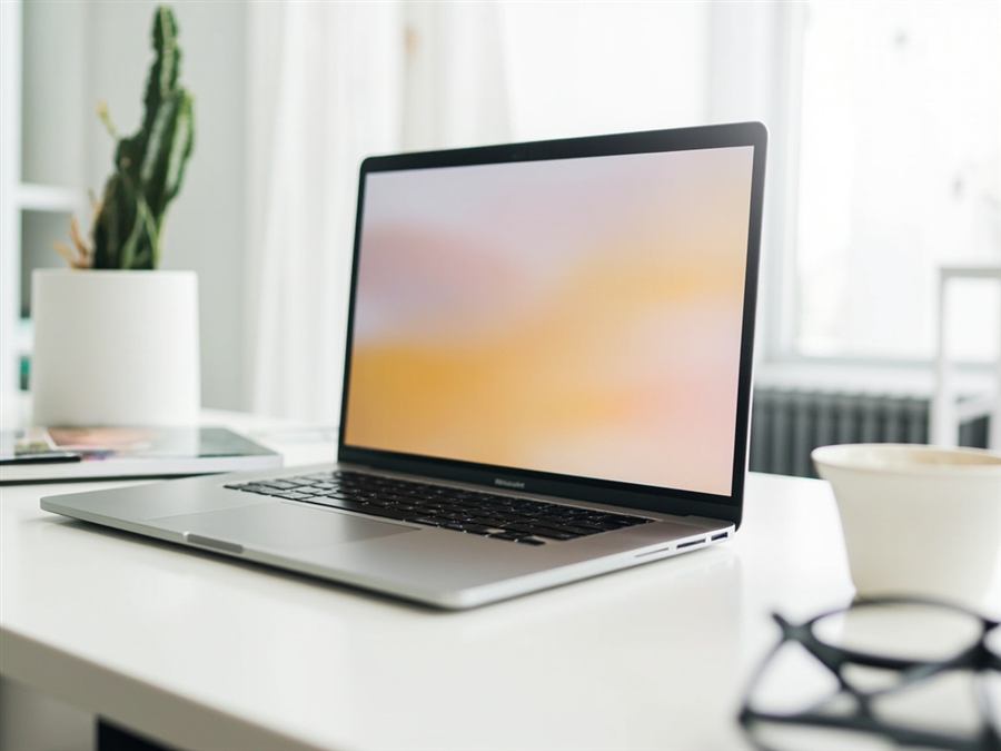 Laptop with abstract gradient screen on a minimalist desk